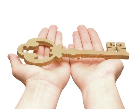 Gold key in hands of the person isolated on white background