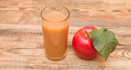 apple with apple juice on a wooden background