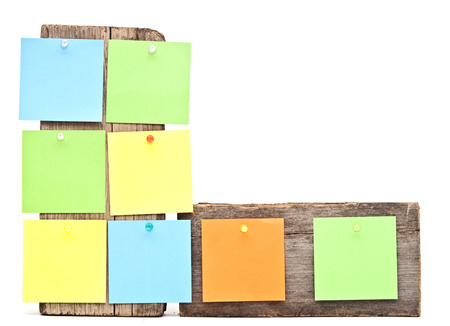 colorful reminder notes attached on a old wooden signboardの写真素材
