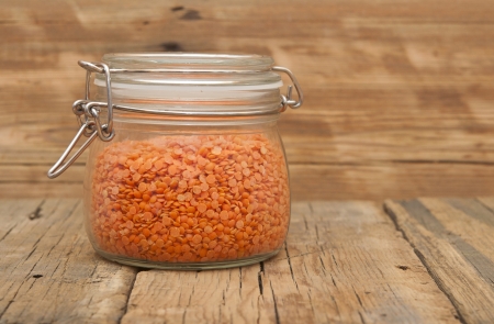 Red split lentils in a jar on a wooden backgroundの写真素材