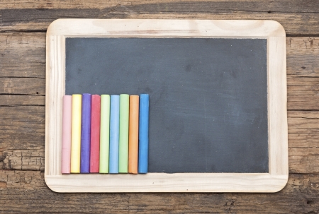 Set of colorful pieces of chalk on blackboard の写真素材
