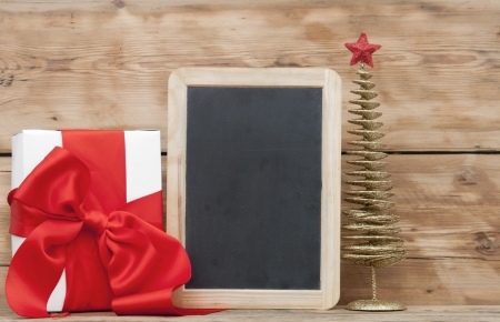 White boxs, red ribbon, christmas ball and blank small blackboard on wood background の写真素材