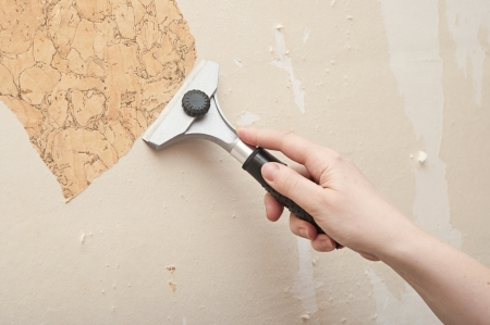 Hand removing wallpaper from wall の写真素材
