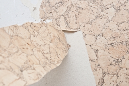 Hand removing wallpaper from wall の写真素材