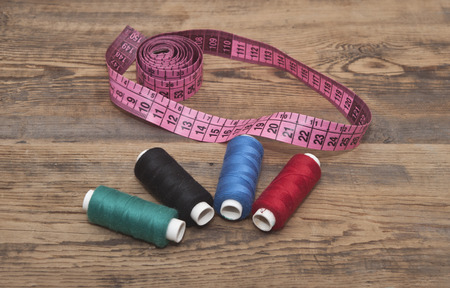 Sewing accessories on wooden background の写真素材