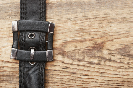 vintage belt buckle on a old wooden board の写真素材