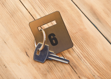 Hotel suite key with room number 6 on wood tableの写真素材