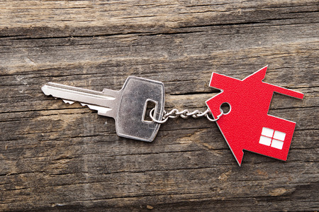 Symbol of the house with silver key on vintage wooden backgroundの写真素材