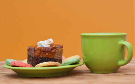tea cup with colorful cookies, and  brown muffin on tableの写真素材
