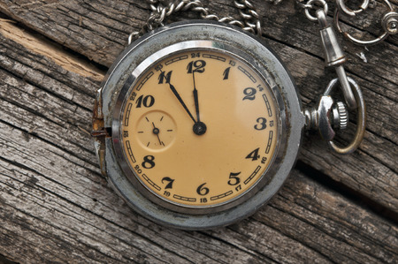 Old pocket watch on a rustic vintage wooden backgroundの写真素材