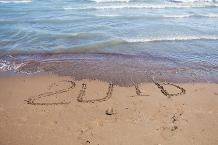2016 written in sand on sunny beachの写真素材