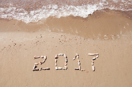 2017 written on sand beach at oceanの写真素材