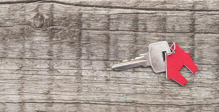 Symbol of the house with silver key on vintage wooden backgroundの写真素材