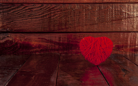 red clew in shape of heart on vintage wooden backgroundの写真素材