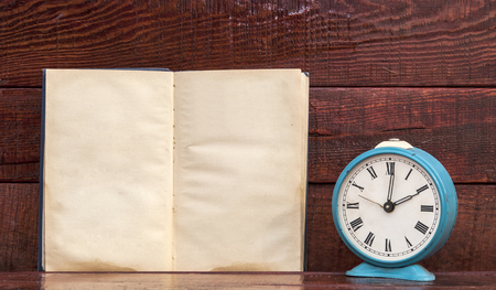 Retro alarm clock and book with wood board backgroundの写真素材