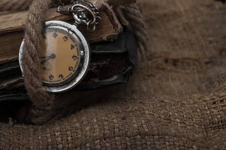 Old pocket watch on a textured vintage backgroundの写真素材