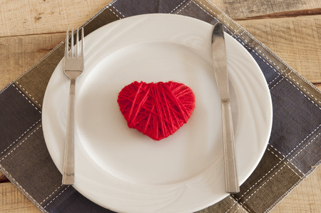 Heart on plate with fork and knifeの写真素材