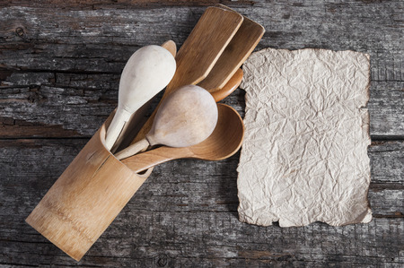 Wooden kitchenware and old blank paper sheets for recipes on wooden backgroundの写真素材