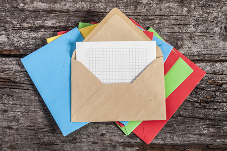many envelopes with white paper on wooden backgroundの写真素材