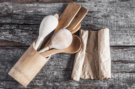 Wooden kitchenware and old blank paper sheets for recipes on wooden backgroundの写真素材