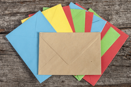 many envelopes with white paper on wooden background