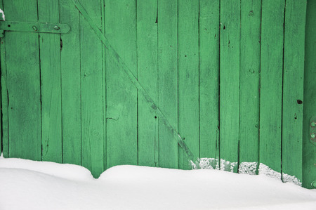 old dark wooden fence in snow.の写真素材