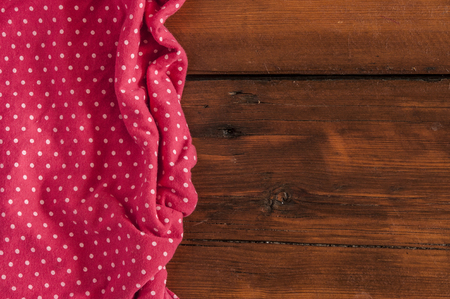 Red polka dot tablecloth over the surface of a wooden tableの写真素材