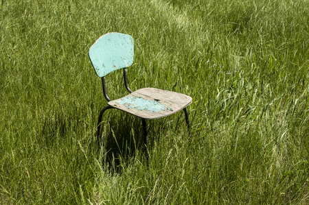 Old wooden chair on green grass.の写真素材