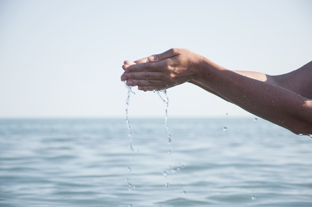 Handful of clear blue waterの写真素材