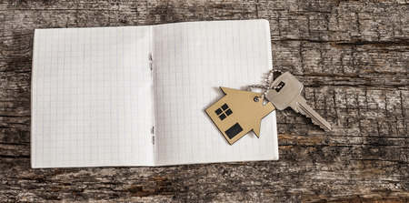 notebook in a cage and key on the wood table