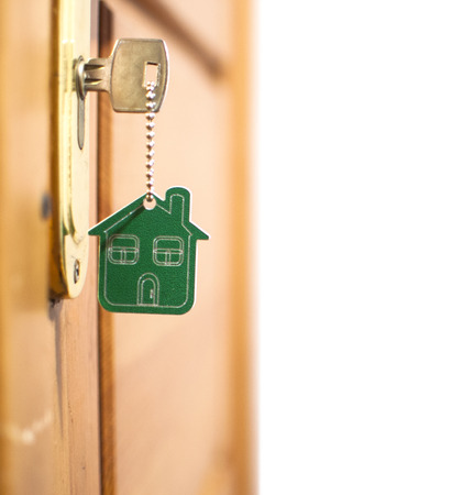 Symbol of the house and stick the key in the keyholeの写真素材