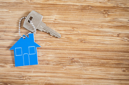 Symbol of the house with silver key on vintage wooden backgroundの写真素材