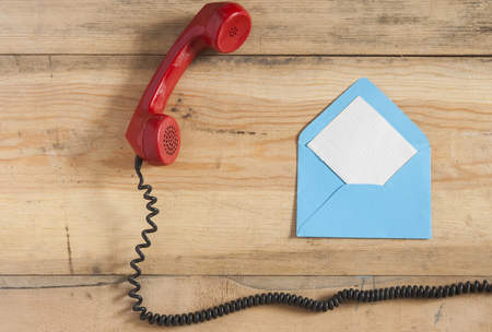 Old red phone cable on wooden backgroundの写真素材