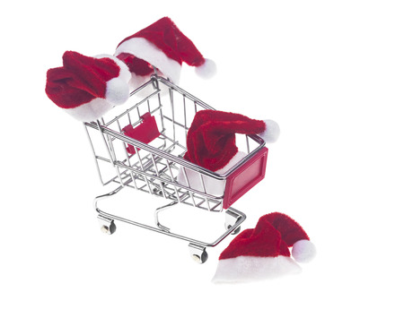 Concept of christmas shopping with santa hat on a shopping cart isolated on a white backgroundの写真素材