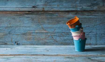 Vertically stacked colorful bucket on wooden backgroundの写真素材