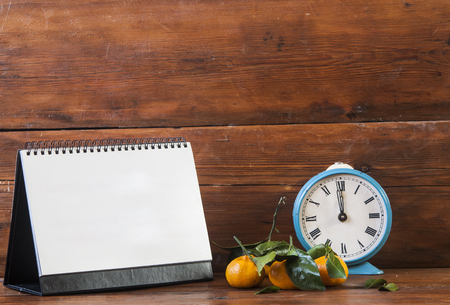 blank calendar with Christmas decoration and mandarins on the dark wooden background. Christmas holidays. の写真素材