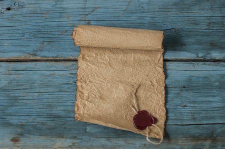 Blank old torn paper with wax stamp on wooden background