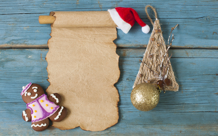 Christmas greeting card, old blank paper sheet, ginger cookies on wooden backgroundの写真素材