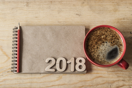 New year's resolution on a notebook and wood number 2018 on wood table, Copy space