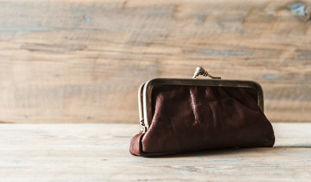brown leather coin purse on a wooden table