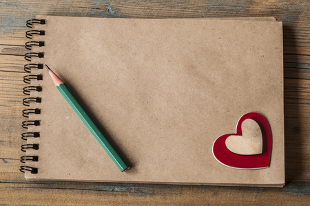 Open blank notebook with Valentine hearts on old wooden backgroundの写真素材