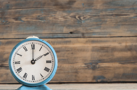 Vintage alarm clock on old wood wall table.