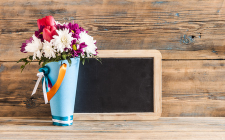 Blackboard with blank space for text, bouquet of flowers on a wooden table の写真素材