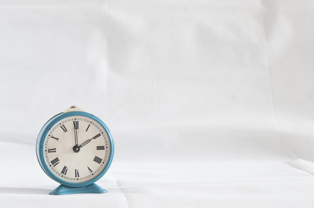 vintage alarm clock with roman numeral on a white background.
