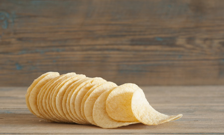 Crispy potato chips on wooden boardsの写真素材