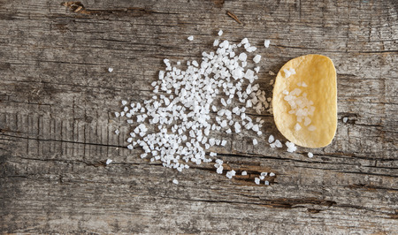 Potato chips with sea salt on a wooden surfaceの写真素材