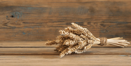 Ears of wheat on old wooden table.の写真素材