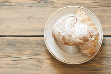 freshly baked croissant on wooden tableの写真素材