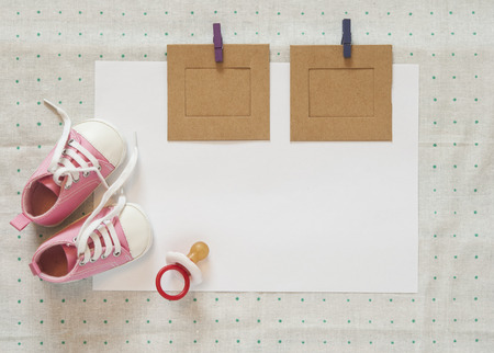 Cute little baby shoes on green polka dot background, top viewの写真素材