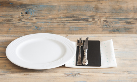 White empty plate with vintage silver ware fork and knife on a polka dot tableclothの写真素材